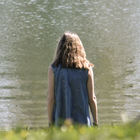 Frau mit langen Haaren am Wasser