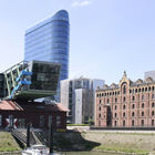 Bürogebäude mit Glasassade, daneben altes Hafengebäude