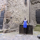 Frau in blauem Kleid vor Eisenplatte