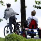 Kinder auf Fahrrad und Tretauto