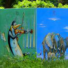 Geige spielender Pinguin und Elefantenfamilie